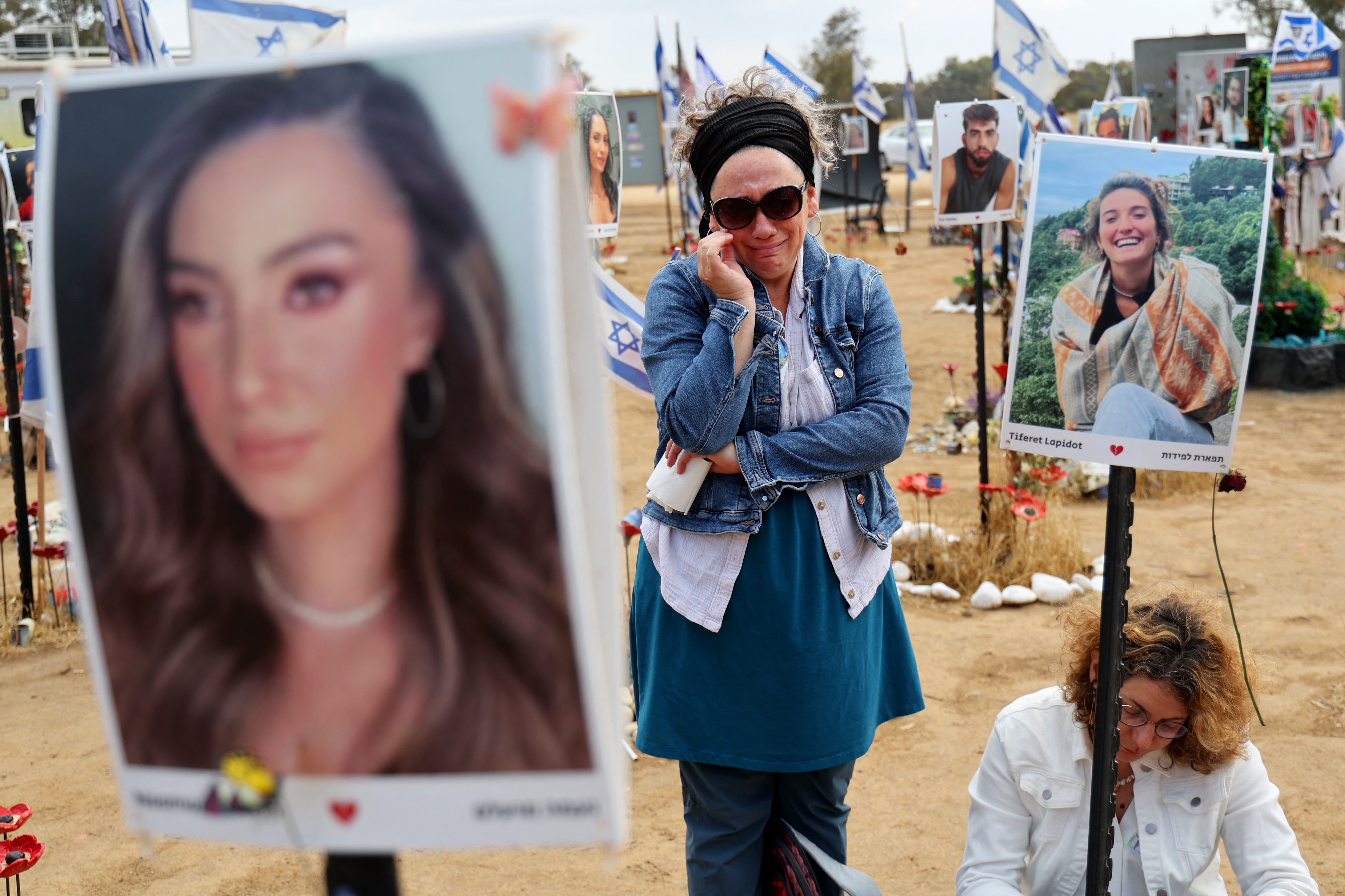 Visitors at a memorial for those hijacked or eliminated in the Hamas attack on the Supernova music celebration on 7 October