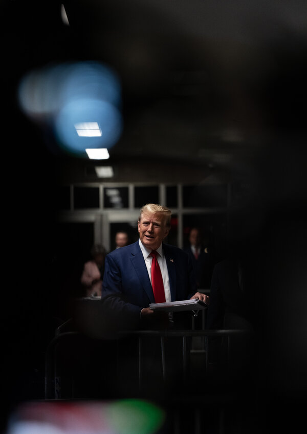 Donald Trump in a courtroom hallway.